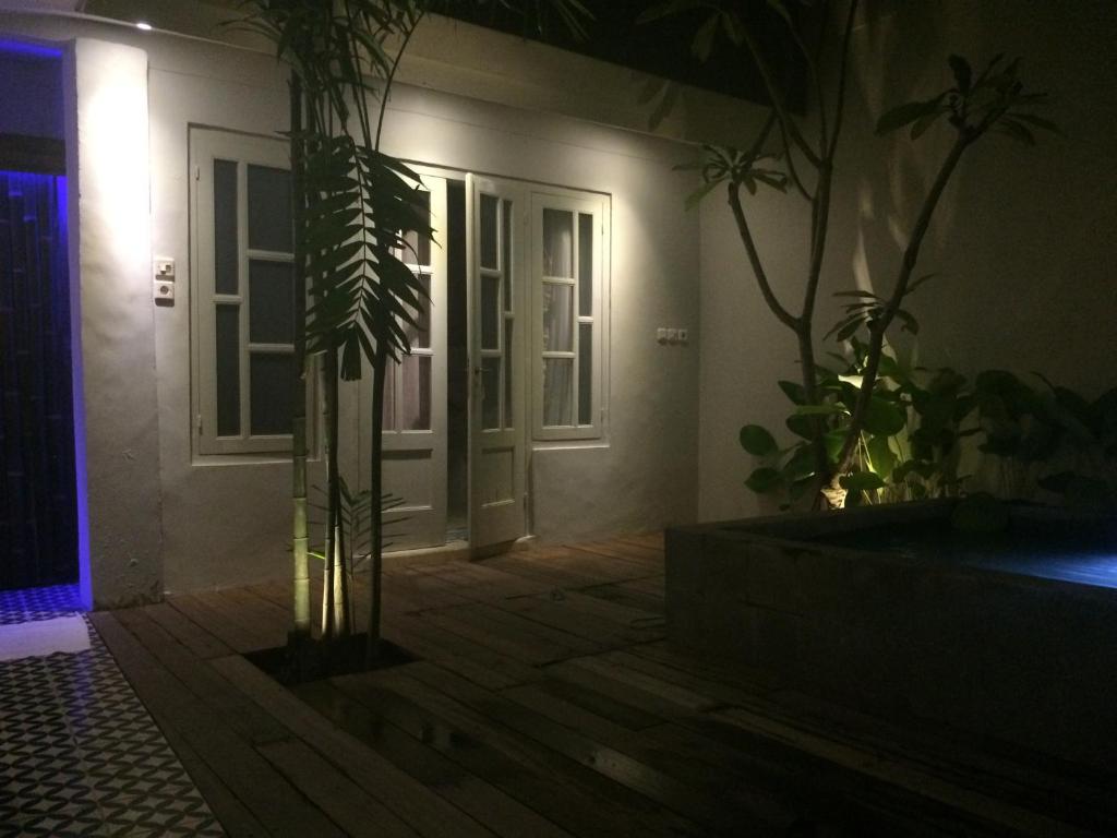 a house with a plant in a room with a door at The Patio Yogya in Yogyakarta