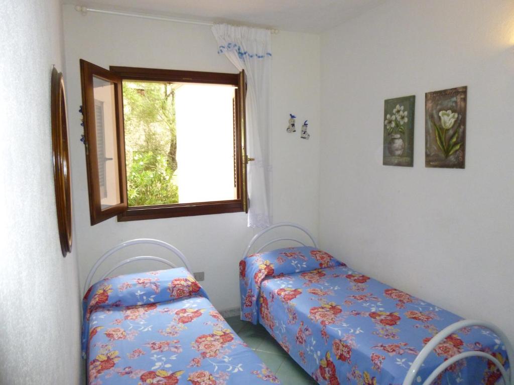 sypialnia z dwoma łóżkami i oknem w obiekcie Le Villette al Centro w mieście San Teodoro