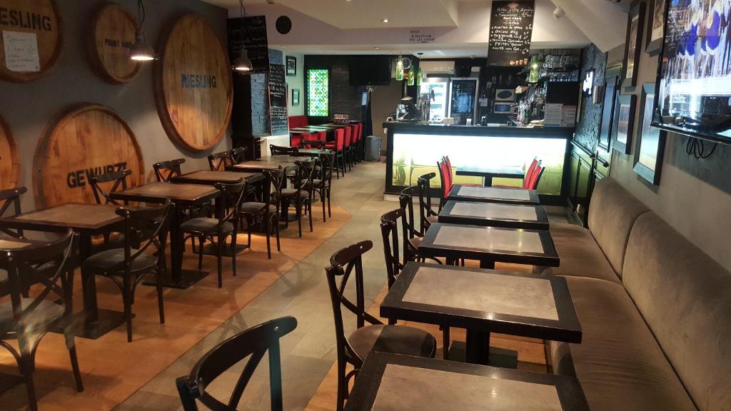 une rangée de tables et de chaises dans un restaurant dans l'établissement Hotel des Voyageurs, à Mayenne