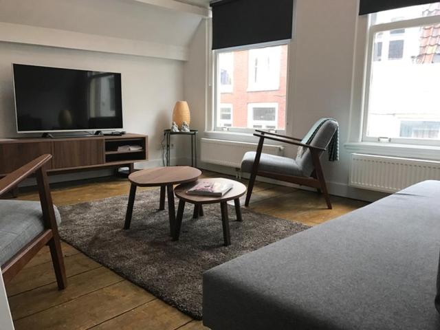 ein Wohnzimmer mit einem Flachbild-TV und einem Sofa in der Unterkunft Maria's Suite in Utrecht