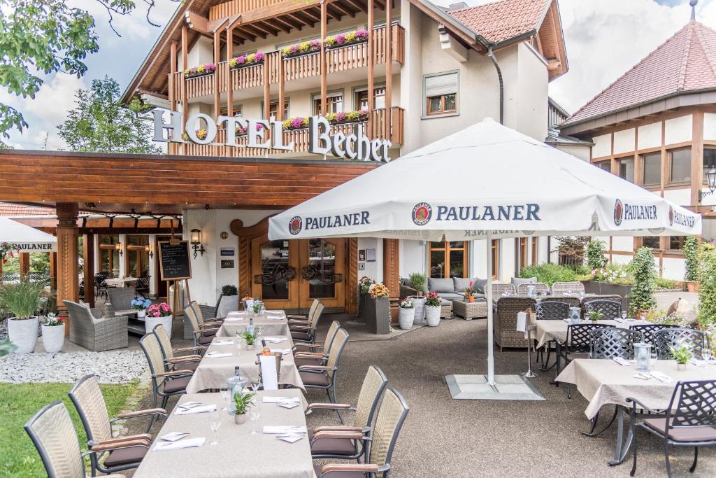 un restaurant avec des tables et des chaises en face d'un bâtiment dans l'établissement Hotel & Restaurant Becher, à Donzdorf