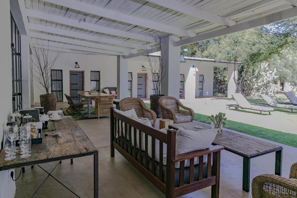 a patio with a wooden table and chairs at The Whyte House in Graaff-Reinet