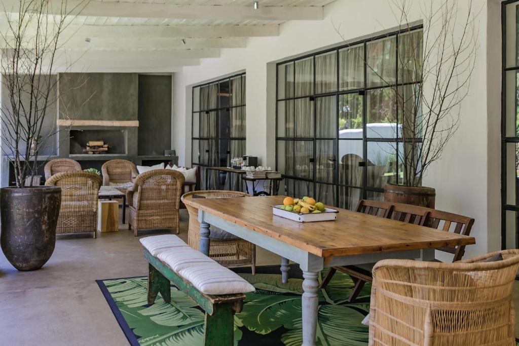 a dining room with a wooden table and chairs at The Whyte House in Graaff-Reinet