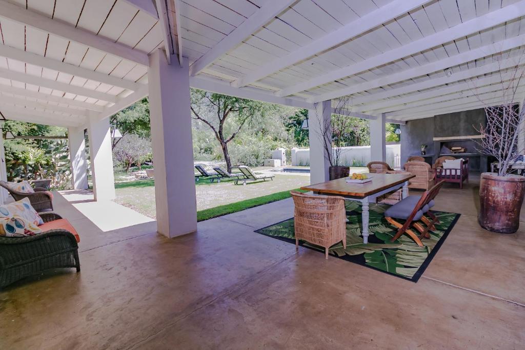 a patio with a table and chairs and a fireplace at The Whyte House in Graaff-Reinet