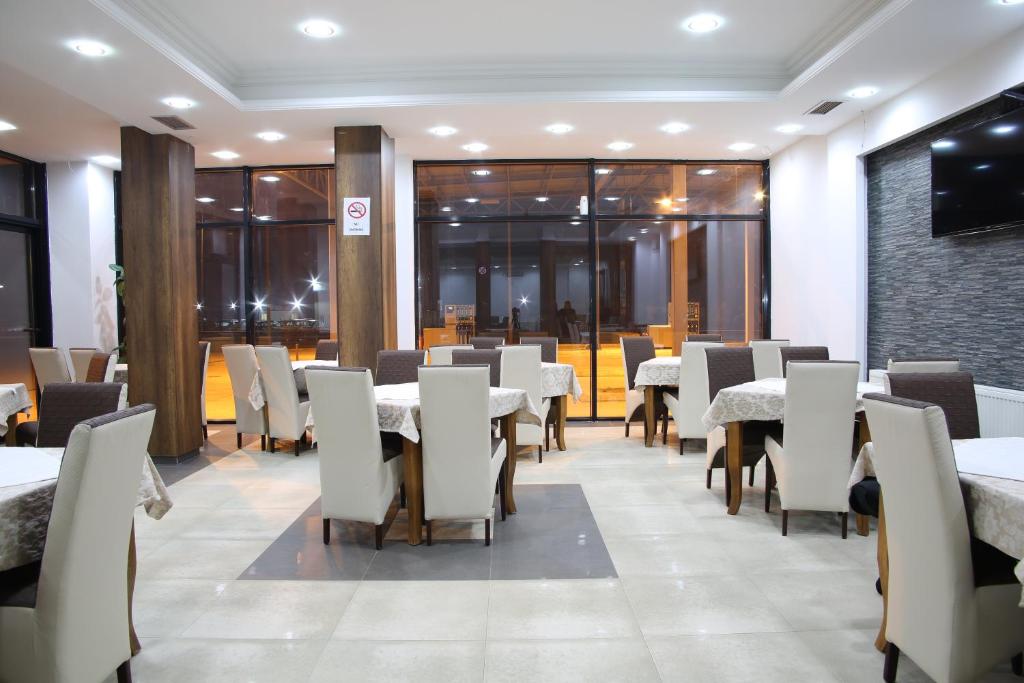 a dining room with white tables and chairs at Hotel Rio in Prishtinë