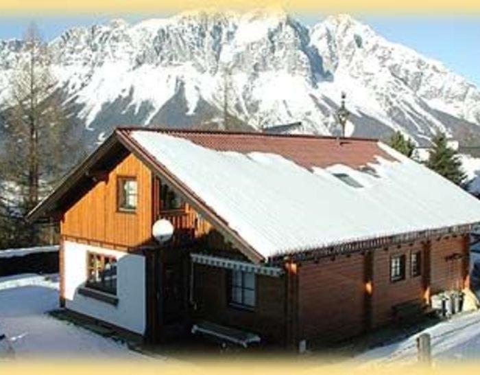 una casa con neve sul tetto con una montagna di Krennbauer a Öblarn
