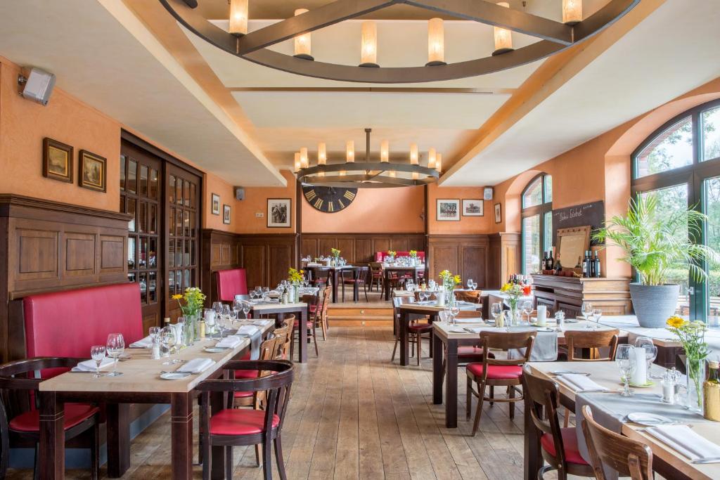 um restaurante com mesas e cadeiras e um lustre em Gasthaus Luthemuhle em Nettetal