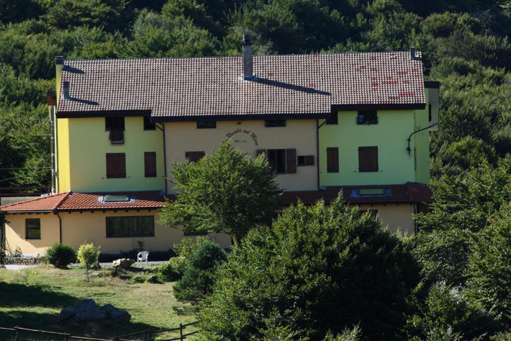 une grande maison blanche avec un toit rouge dans l'établissement La Nuvola sul Mare, à Vara Superiore