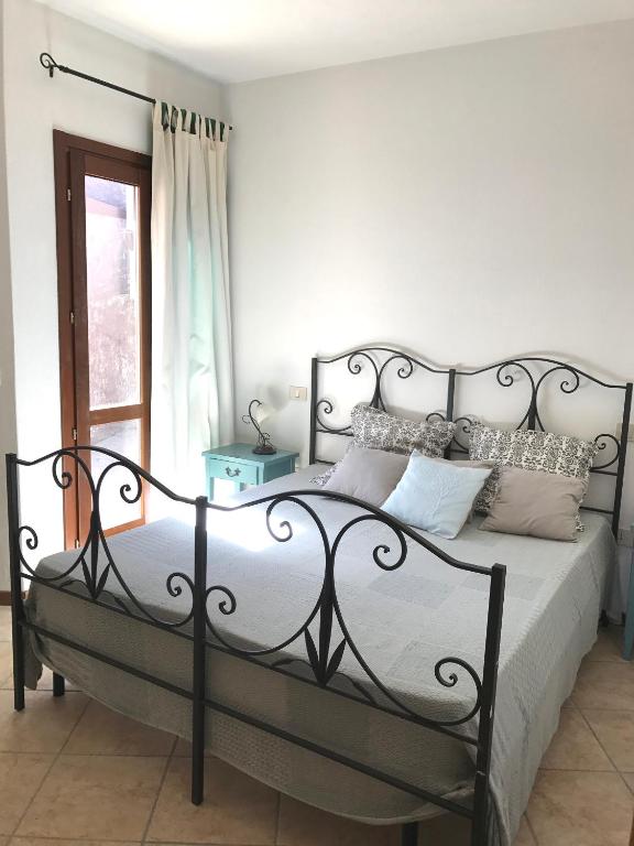 a bedroom with a black metal bed with pillows at Sa Tirìa in Chia