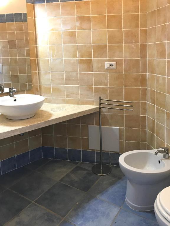 a bathroom with a sink and a toilet at Sa Tirìa in Chia