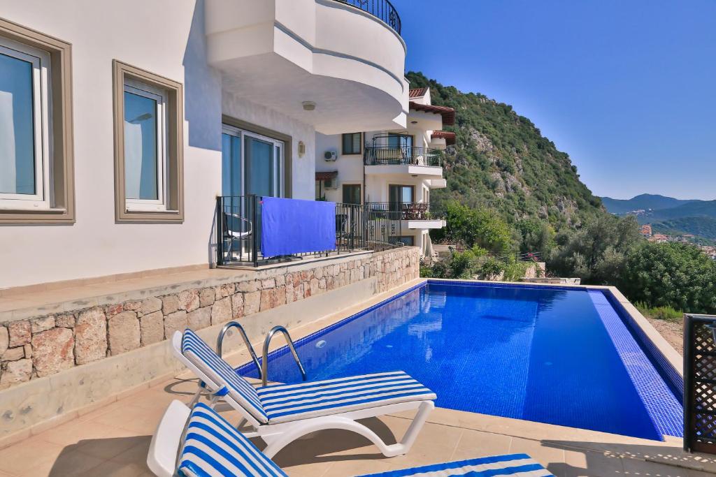 a villa with a swimming pool and a house at Braeside Apartment in Kaş