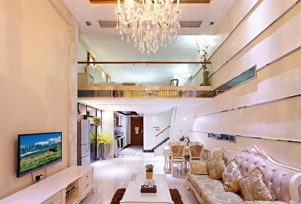 a living room with a couch and a chandelier at Guangzhou Ba Dun Hotel - Beijing Road in Guangzhou