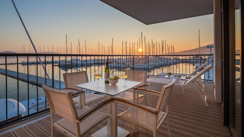 einen Balkon mit einem Tisch und Stühlen auf einem Boot in der Unterkunft Marina Baotić Apartments in Trogir