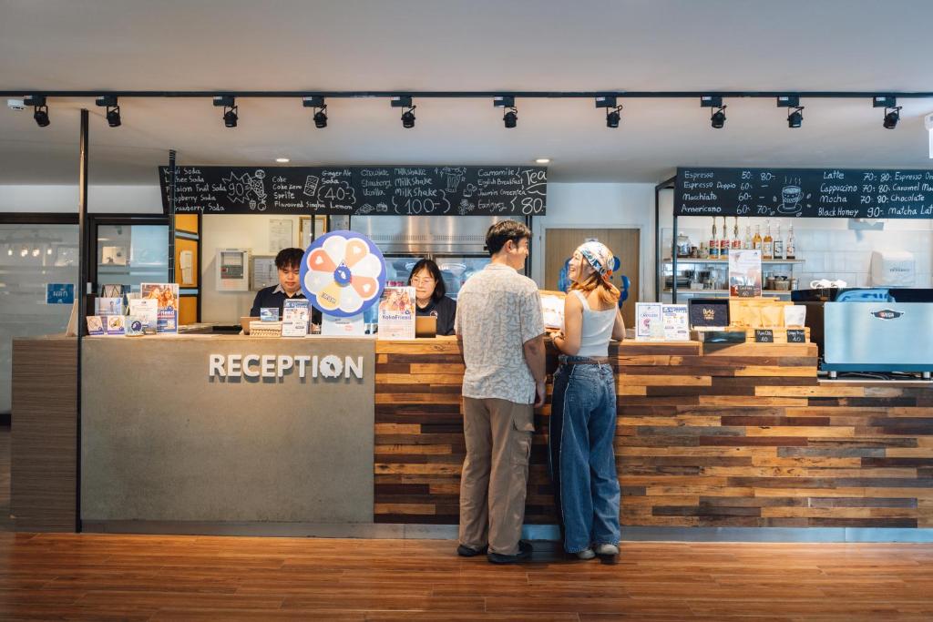 Reception counter with a café-style service area and hotel shop displays.