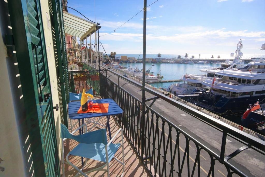 a balcony with two tables and a marina with boats at casa Parisi in Imperia