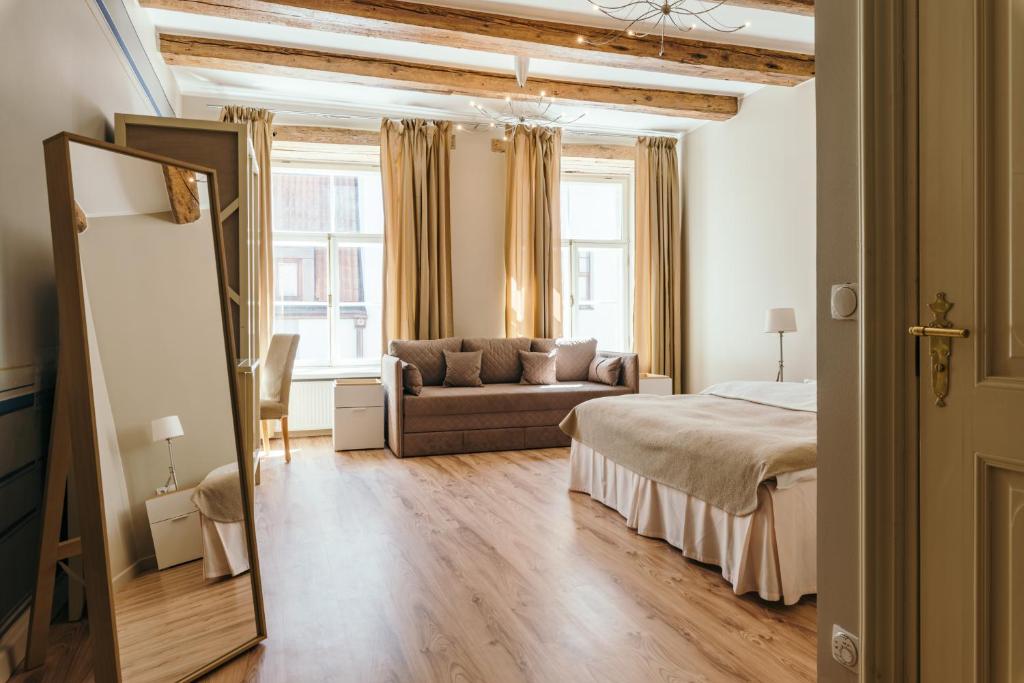 ein Schlafzimmer mit einem Bett und einem Sofa in einem Zimmer in der Unterkunft Merchants House Hotel in Tallinn