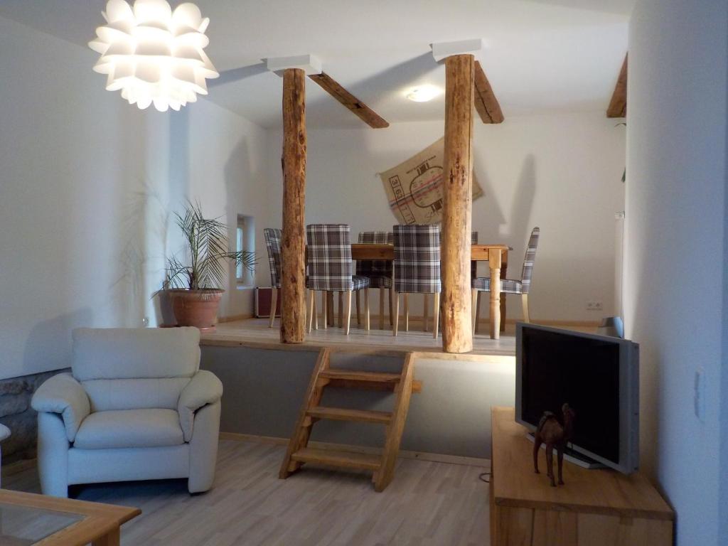ein Wohnzimmer mit einem TV, einem Sofa und einem Stuhl in der Unterkunft Ferienhaus Schock in Thale