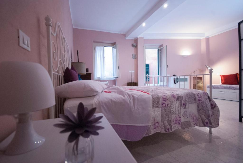 a pink bedroom with a bed and a lamp at Cà de Lelio in Manarola