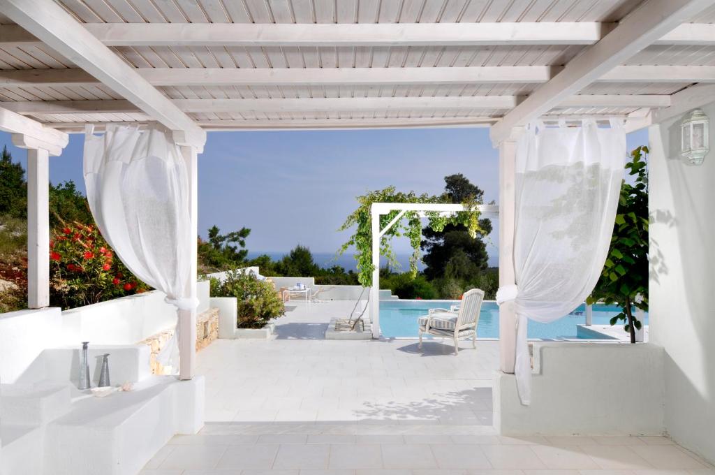 a white pergola next to a swimming pool at Anemolia Villas with private pools near the most beautiful beaches of Alonissos in Alonnisos