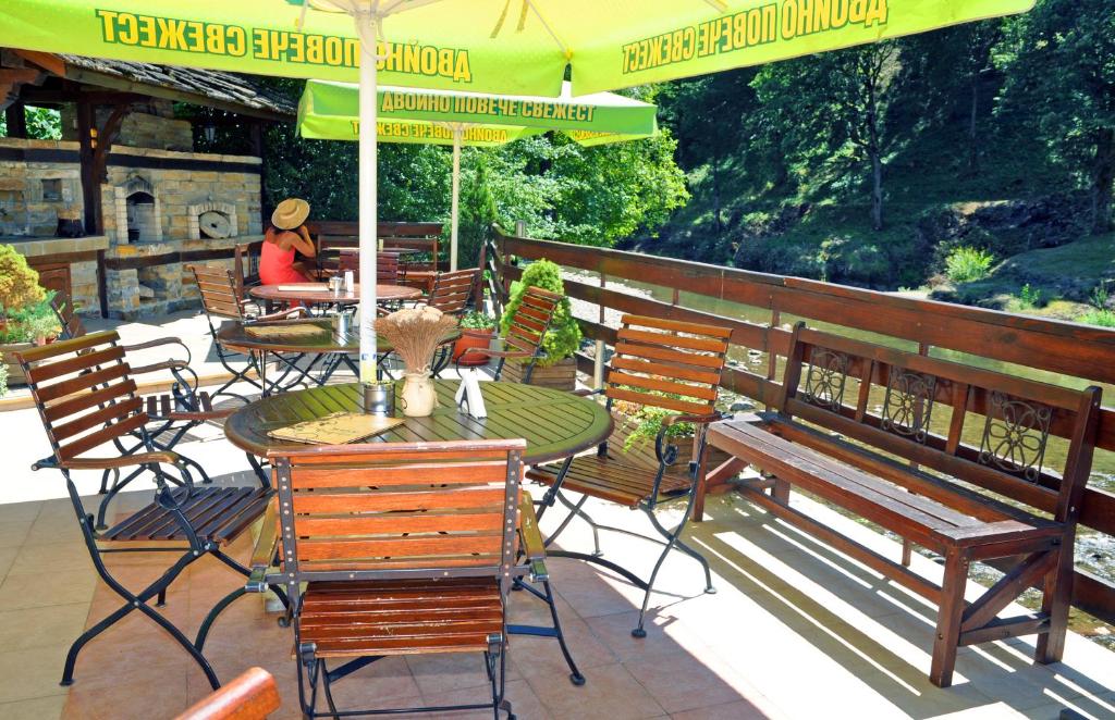 a patio with a table and chairs and an umbrella at Семеен хотел Федора in Ribarica