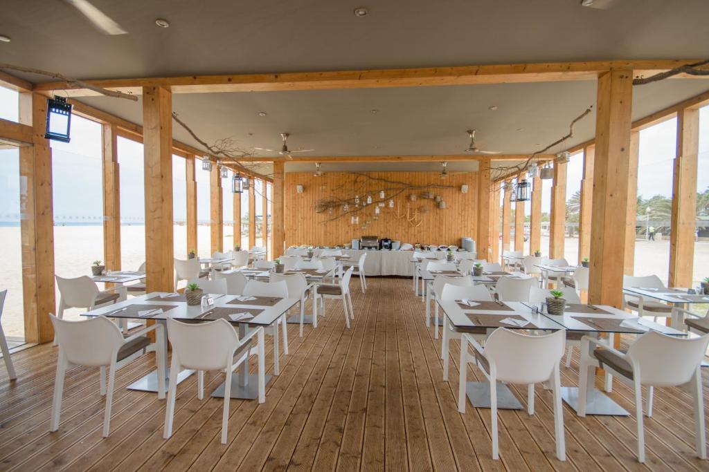 un comedor con mesas blancas y sillas blancas en Oasis Salinas Sea, en Santa Maria