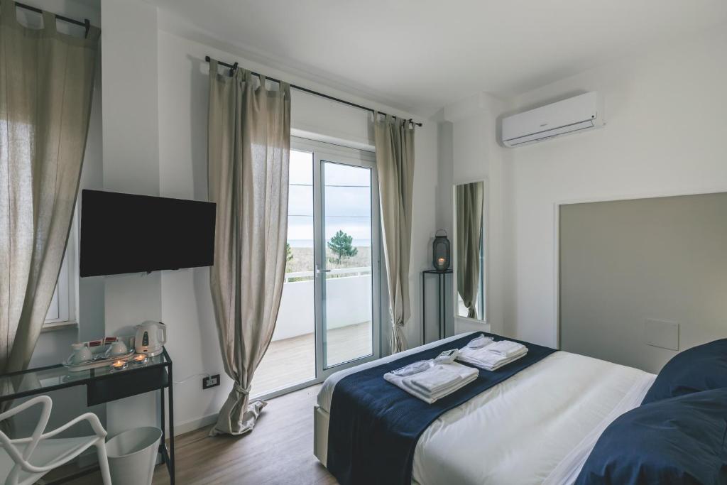 una camera d'albergo con un letto e una grande finestra di Le Dune di Villa Diana a Vasto