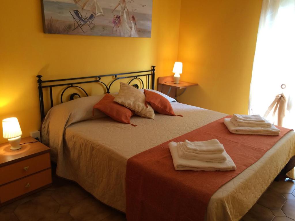 a bedroom with a bed with two towels on it at Etna View Affittacamere in Giardini Naxos