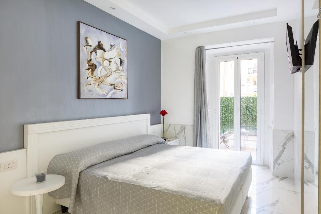 a white bedroom with a bed and a window at Little Aurelius in Rome