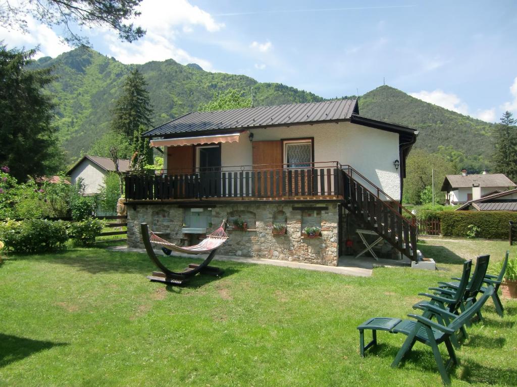 ein Haus mit einem Balkon und zwei Bänken im Hof in der Unterkunft Casa Max in Ledro