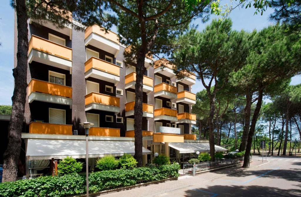 an apartment building with trees in front of it at Hotel San Pietro in Cervia