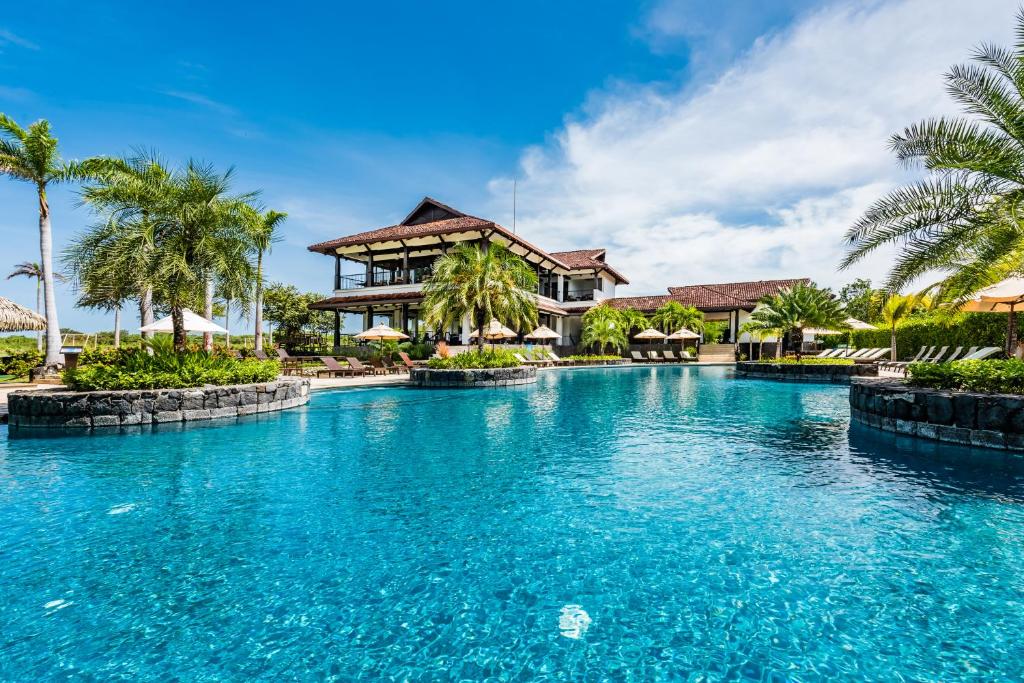 una piscina frente a un complejo en Luxury Vacation Rentals At Hacienda Pinilla en Tamarindo