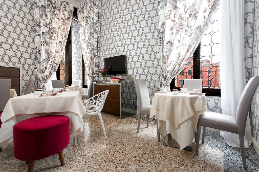 a restaurant with two tables and chairs and a window at Hotel Ca' Nobile Corner in Venice