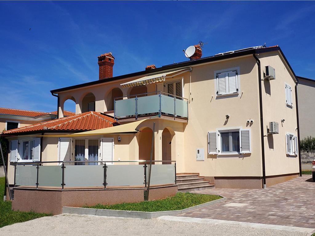 a large house with a balcony on top of it at Willa Trojka in Novigrad Istria