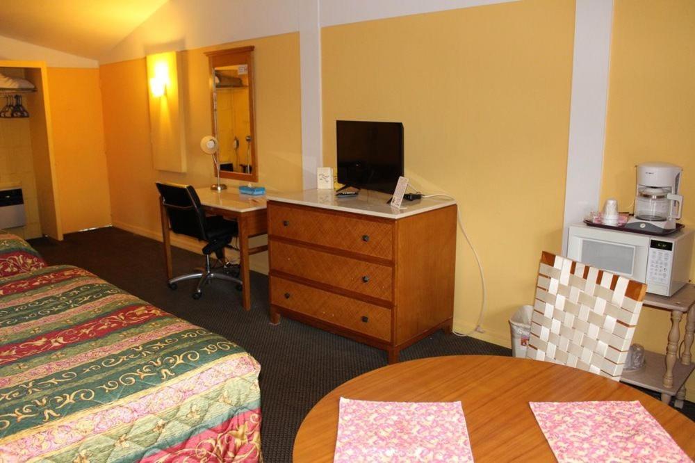 um quarto de hotel com uma cama e uma secretária com um computador em Warm Mineral Springs Motel em North Port
