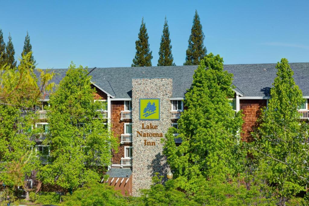 Lake Natoma Inn في فولسوم: مبنى فيه لافته امام الاشجار