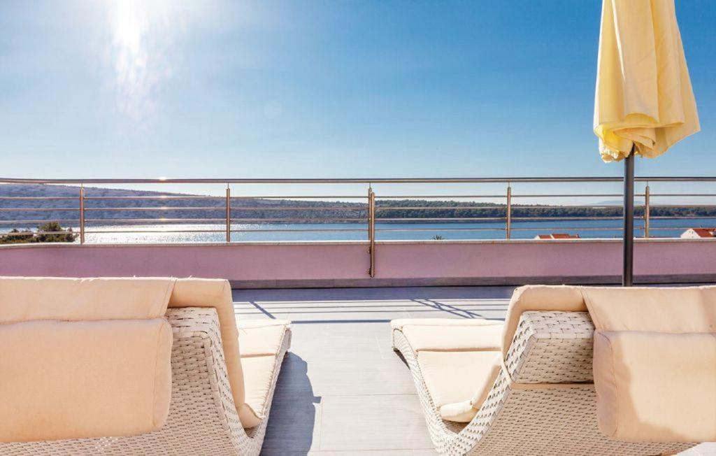 a balcony with two chairs and an umbrella at Apartments Host in Rab