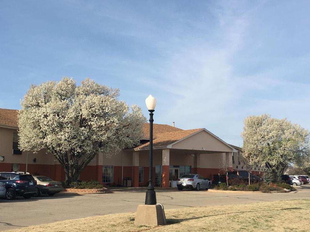 um edifício com uma luz de rua num parque de estacionamento em Territorial Inn Guthrie Oklahoma em Guthrie