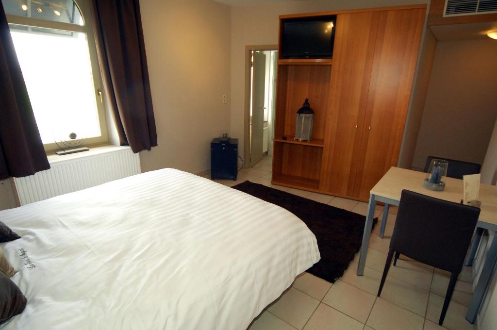 Postel nebo postele na pokoji v ubytování Hôtel Le Saint Loup
