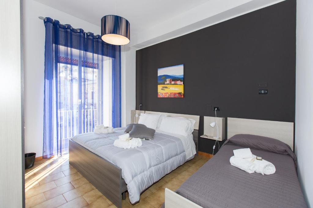 a bedroom with two beds and a large window at B&B Albergo Sicilia in Avola