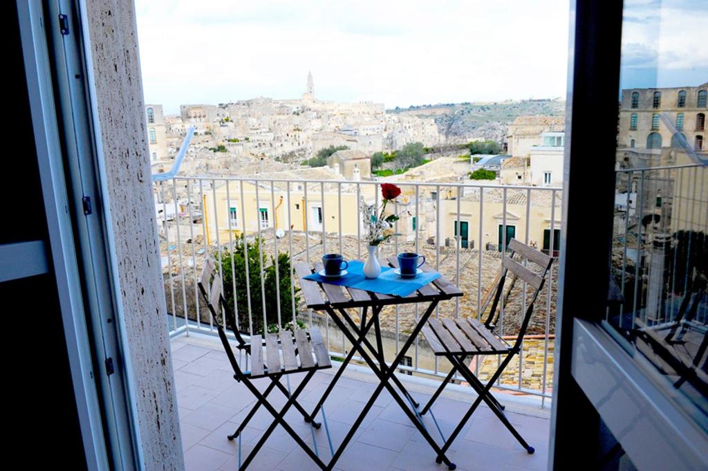 a table and chairs on a balcony with a view at Dimore Le Lucane in Matera