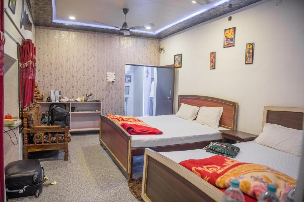 a hotel room with two beds and a bathroom at Kanha Paying Guest House in Varanasi