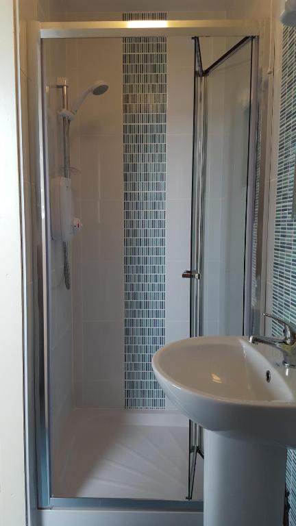 a bathroom with a shower and a sink at An Creagán Rooms in Inisheer