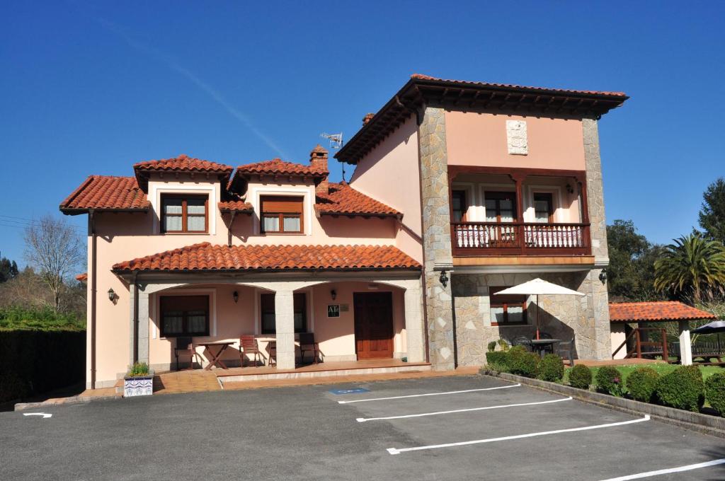 a house with a parking lot in front of it at Apartamentos Al pie de Mañanga in Parres de Llanes