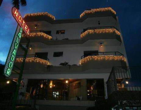 un edificio con una señal de calle delante en Hotel Salvador, en Poços de Caldas