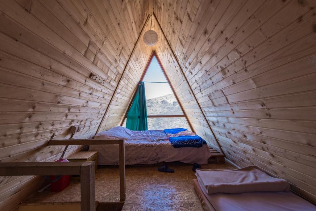 Una pequeña habitación con una cama y una ventana. en Villa Kalaja, en Novoberdo
