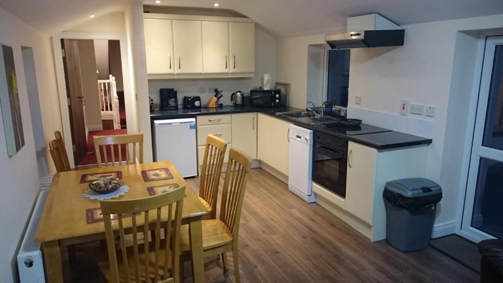 a kitchen with a table and a table and chairs at Esker House in Donegal