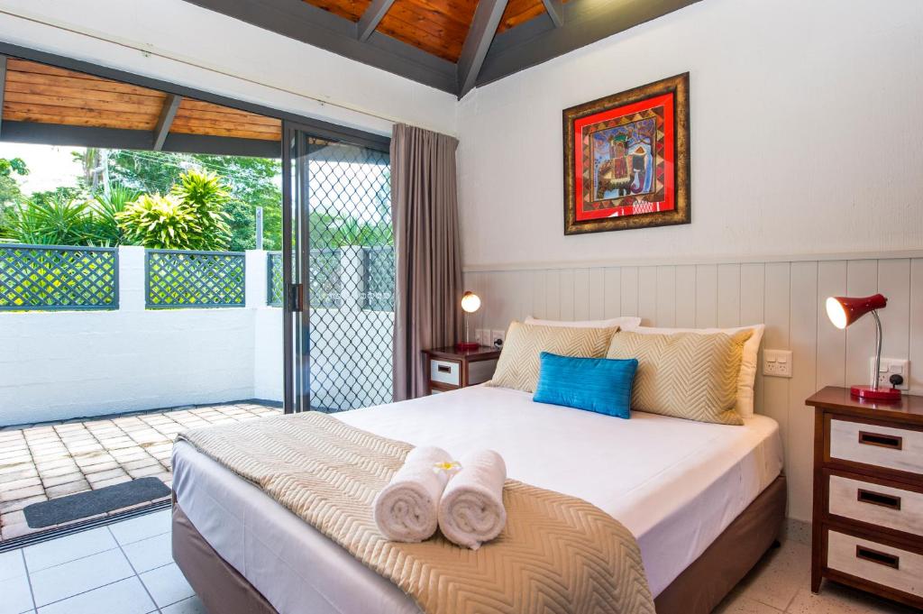 a bedroom with a bed with towels on it at Island Leisure Resort in Nelly Bay