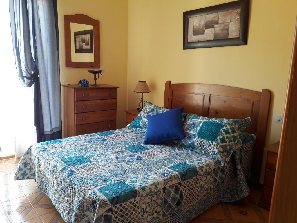 Un dormitorio con una cama con un edredón azul. en Apartamentos Vista La Maroma, en Viñuela