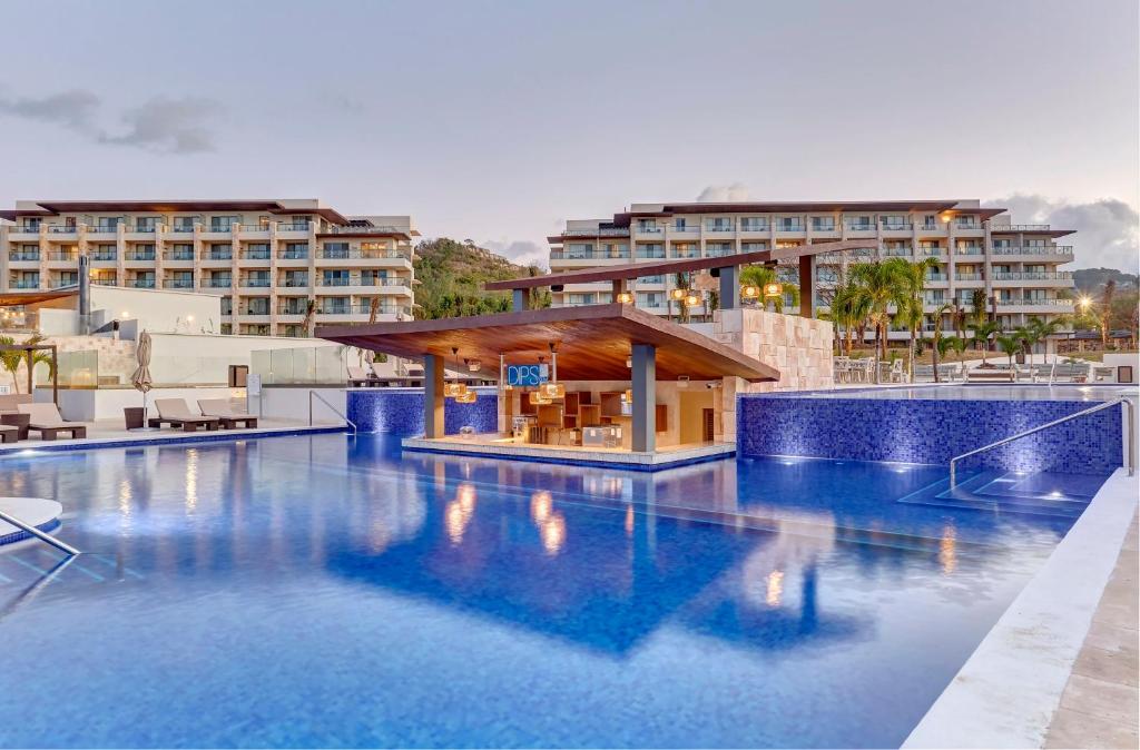 a swimming pool with a hotel in the background at Royalton Saint Lucia, An Autograph Collection All-Inclusive Resort in Gros Islet