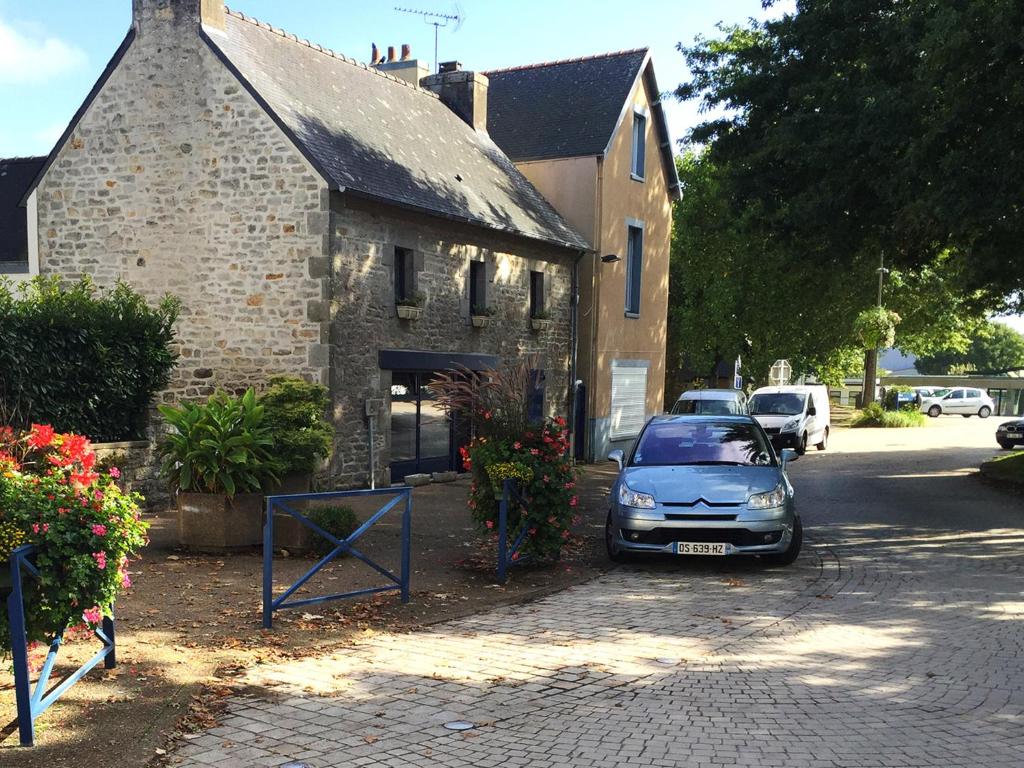 um carro estacionado em frente a um edifício de tijolos em Brittany Vacation Rental em Plomelin